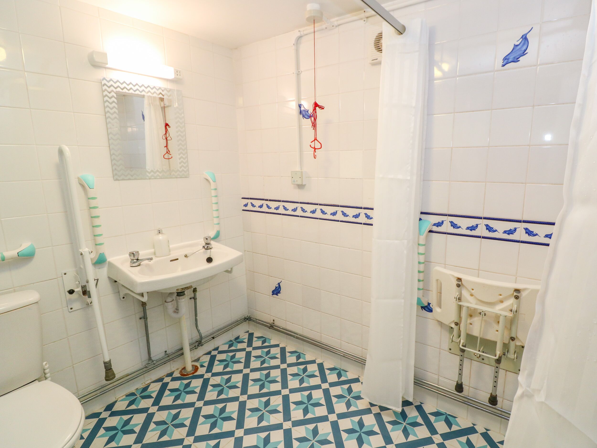 Een badkamer met een wit wastafel, toilet en douche.