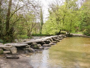 A stone bridge over a calm river, surrounded by lush greenery and trees. - 3 Elm Cottage (Minehead)