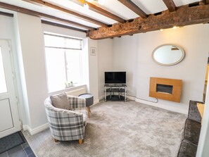 Relax in this stylish living room with a comfortable sofa, flat-screen TV, and elegant wooden cabinet.