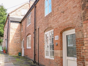 End Cottage features a traditional brick exterior with white window frames and a classic entrance.
