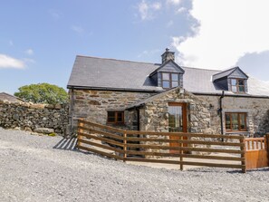 A stone house with a wooden fence, a stone wall, and a gravel driveway. - Yr Hen Stabal (Blaenau Ffestiniog)