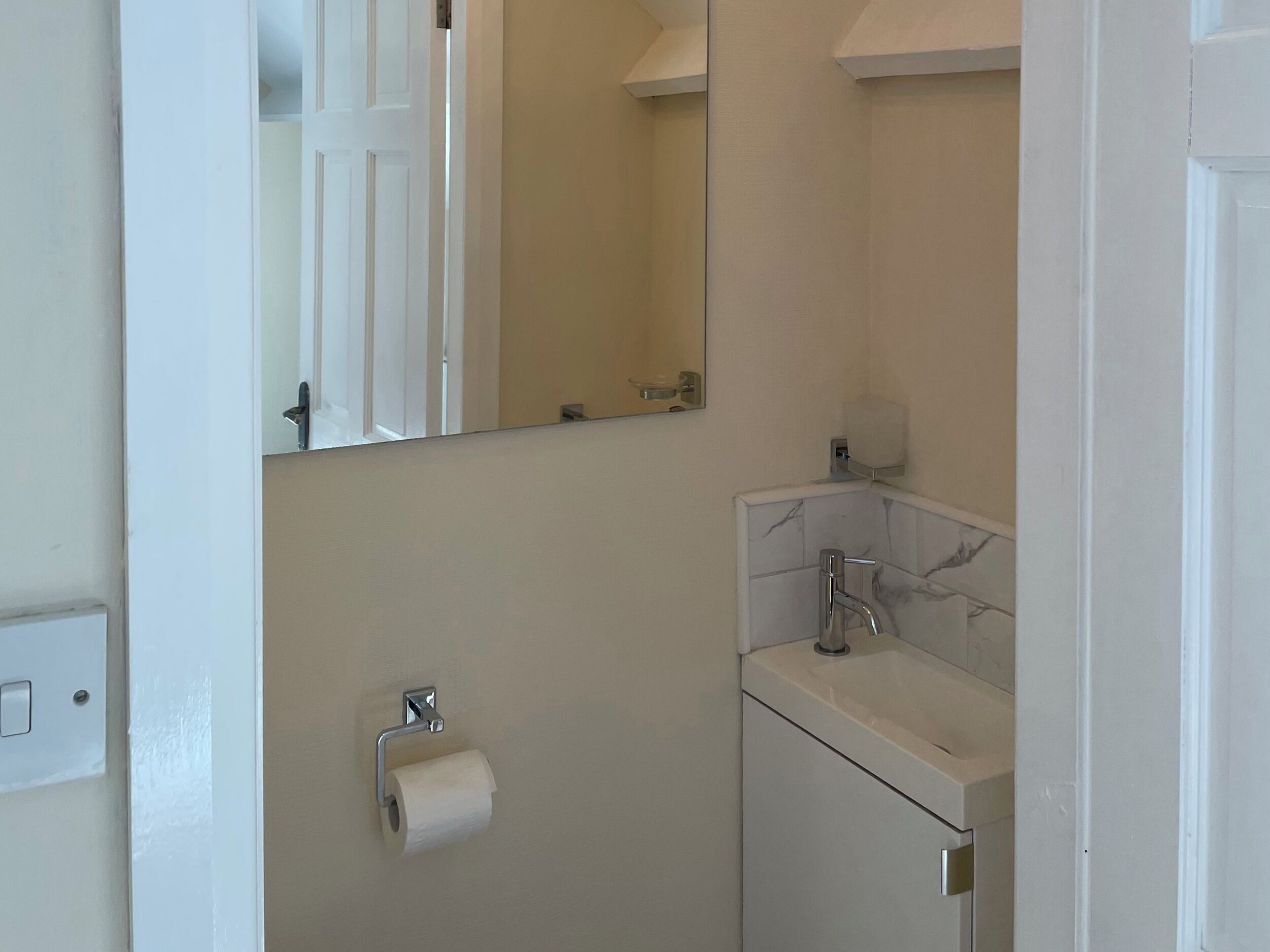 Un bagno con portasciugamani, lavandino e specchio.