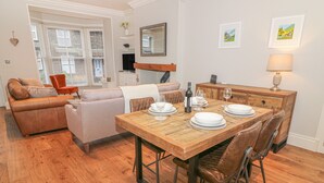 A dining area with a wooden table set for four, surrounded by leather chairs. - Little Herdwick (Windermere)
