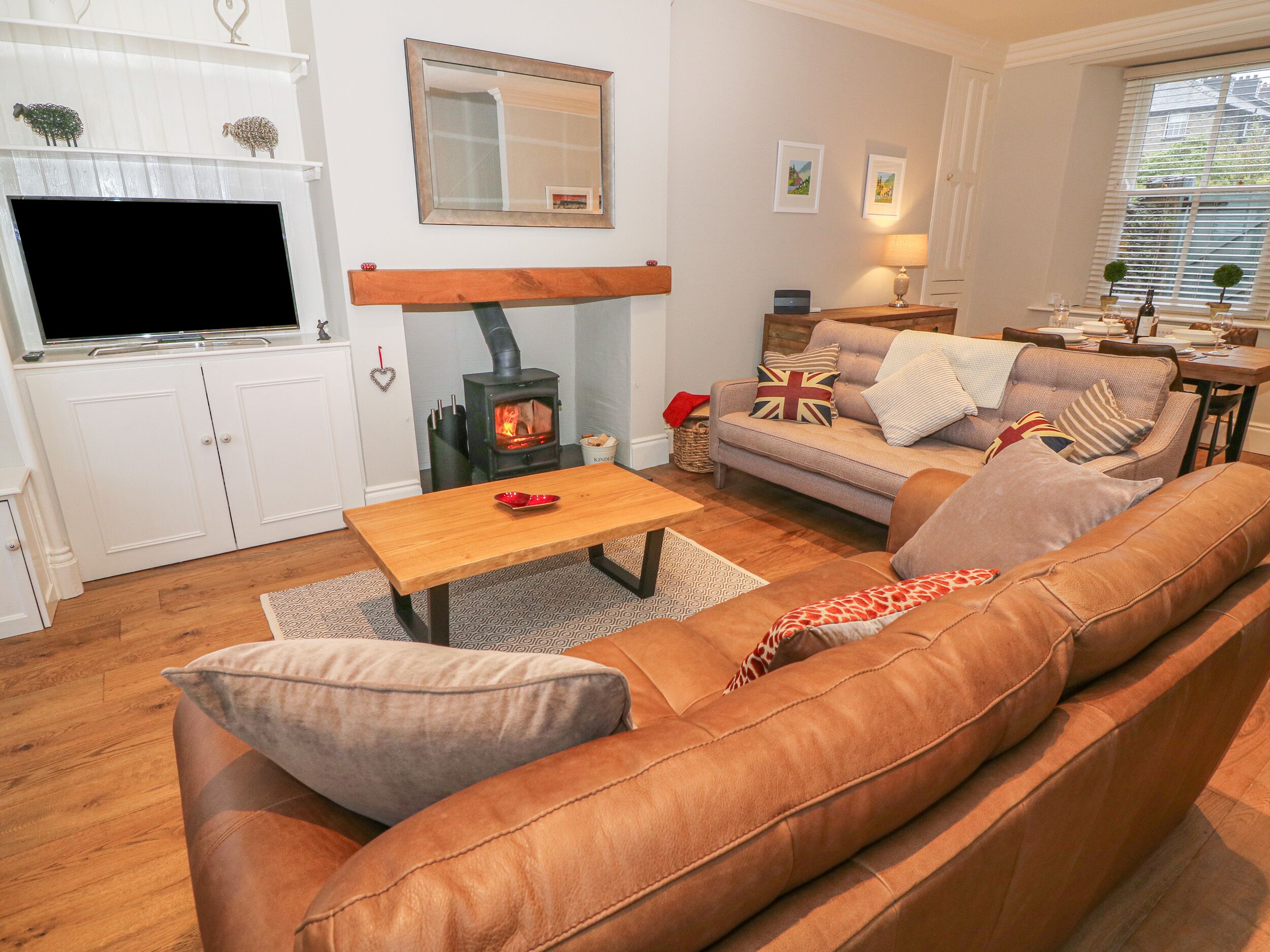 A cozy living room with a sofa, a wooden table, and a fireplace.