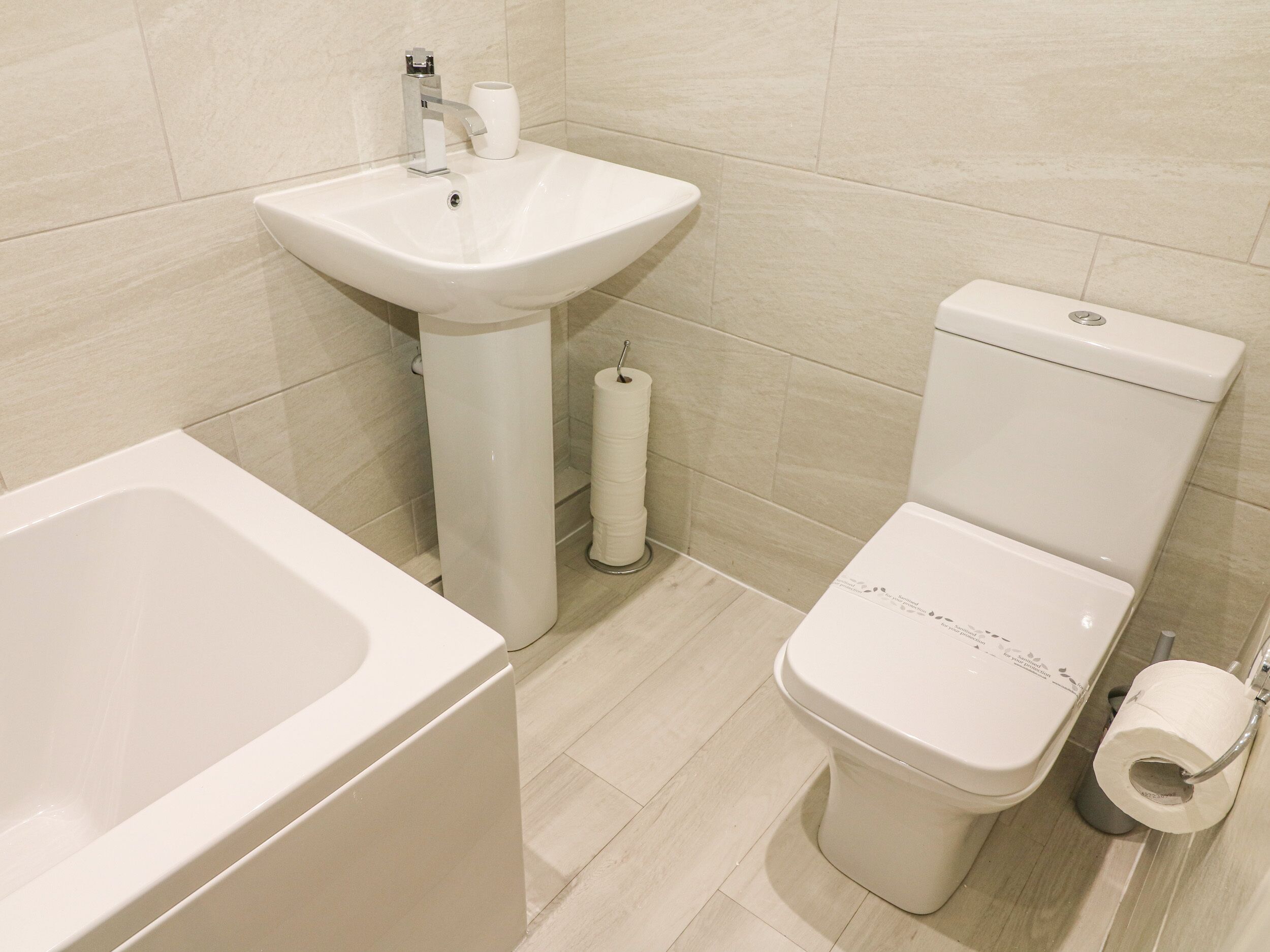 Ein Badezimmer mit Waschbecken, Toilette und einer Rolle Toilettenpapier.