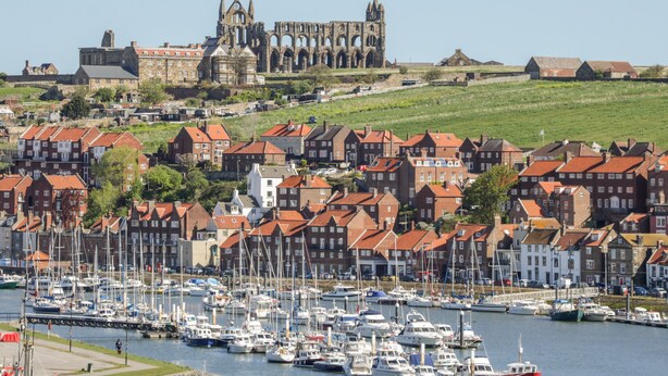 A coastal town with a historic church and marina.