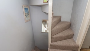 A carpeted staircase in a room with light-colored walls. - Cobbles House (Whitby)
