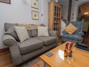 A living room with a grey sofa, a blue armchair, and a wooden cabinet.