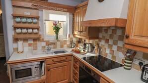 A kitchen with wooden cabinets, a built-in oven, a sink, and a stove.