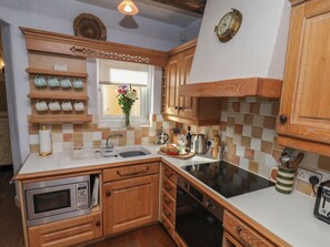 A kitchen with wooden cabinets, a built-in oven, a sink, and a stove.
