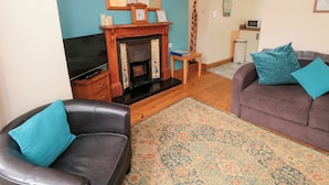 A living room with a fireplace, a sofa, a loveseat, and a patterned rug.