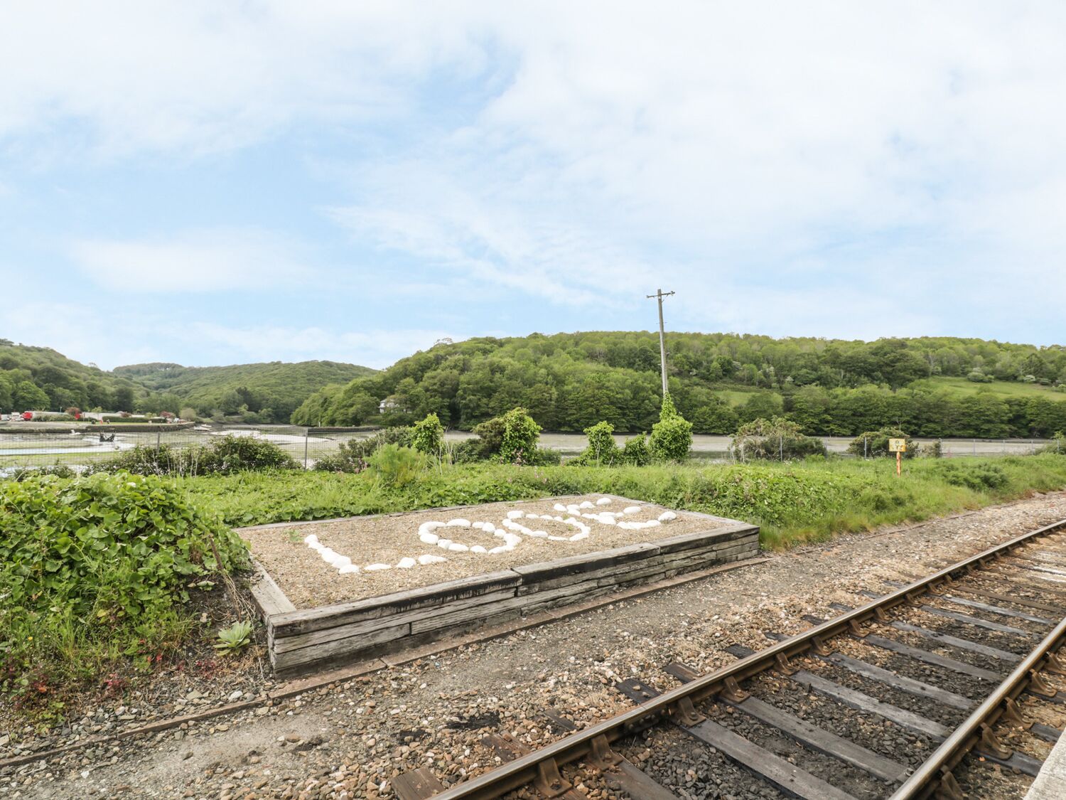 Une voie ferrée avec une dalle de béton au premier plan, sur laquelle est inscrit le mot « PERDU ».