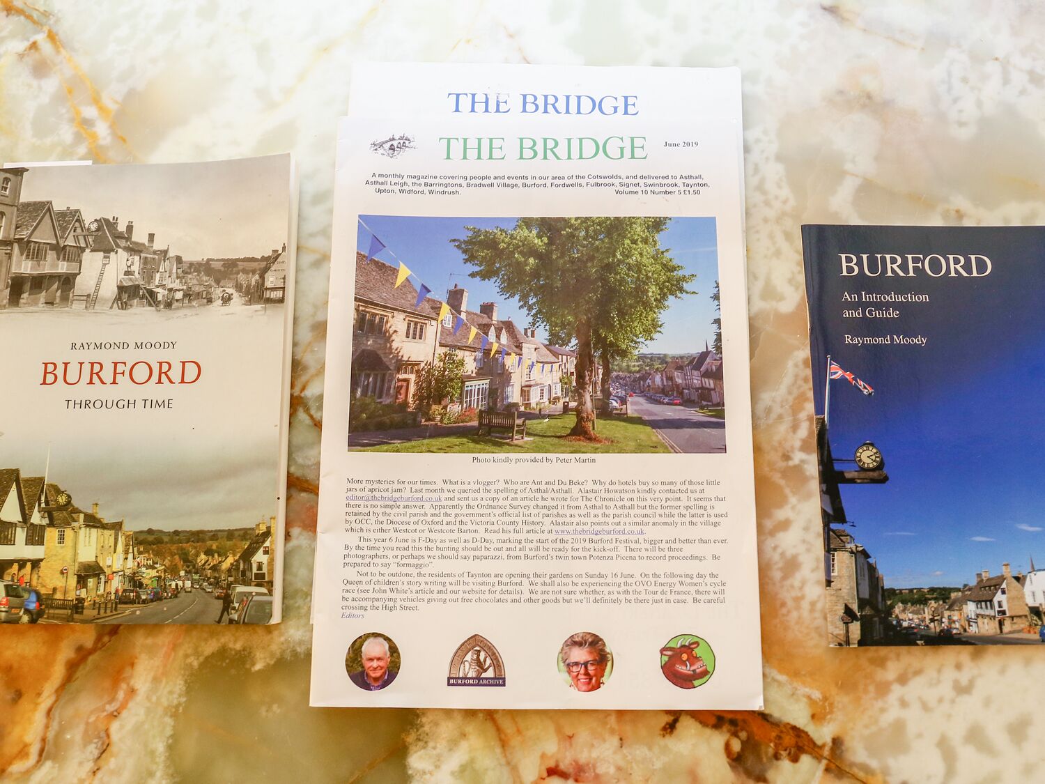A book titled 'BURFORD THROUGH TIME' by Raymond Moody, featuring historical photographs of Burford.