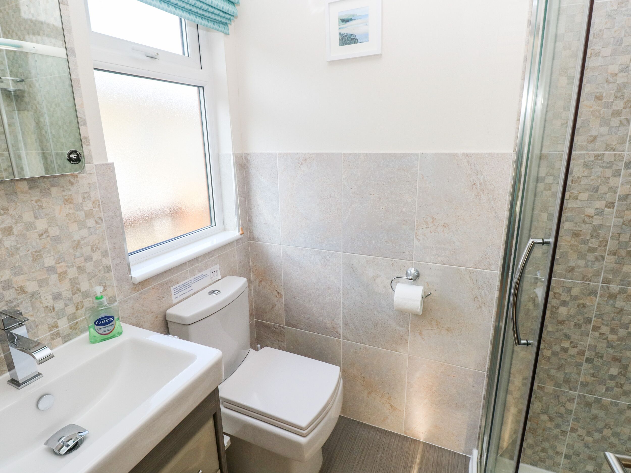 A bathroom with a sink, toilet, and shower.