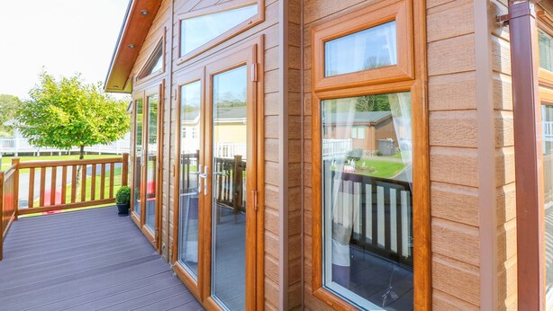 Eine Holzwand mit großen Fenstern und einer Terrasse.