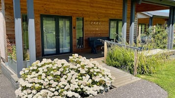 Guests can enjoy a covered porch with a seating area and garden views.
