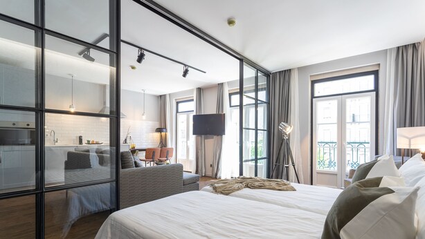 Una habitación de hotel moderna con una cama grande, un escritorio, una silla y un televisor.