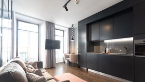 Una sala moderna con sofá, reposapiés y un comedor con sillas.