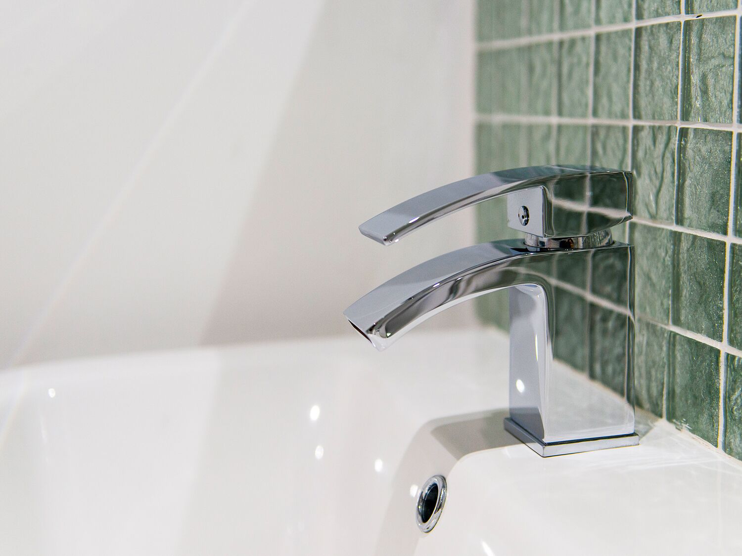 A chrome faucet with a single handle and a side drain.