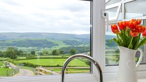 A window with a view of rolling hills and a rural road. - Caesamson (Caersws)