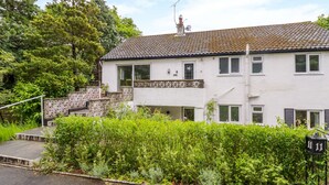 A two-story house with a tiled roof, a balcony, and a number '11' sign. - Tanglewood (Colwyn Bay)