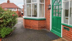 A corner house with a green door, white-framed windows, and a brick exterior. - Hillcrest (Scarborough)