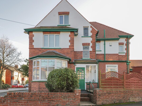 A two-story house with a green door, a bay window, and a brick facade. - Hillcrest (Scarborough)