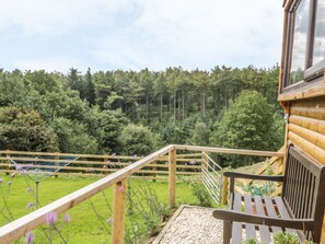 A wooden cabin with a wooden deck and a view of a forest. - Castle View Cabin (Scarborough)