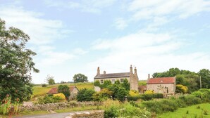 A rural road leading to a stone house with a garden and a stone wall. - Pheasant Cottage (Bath)