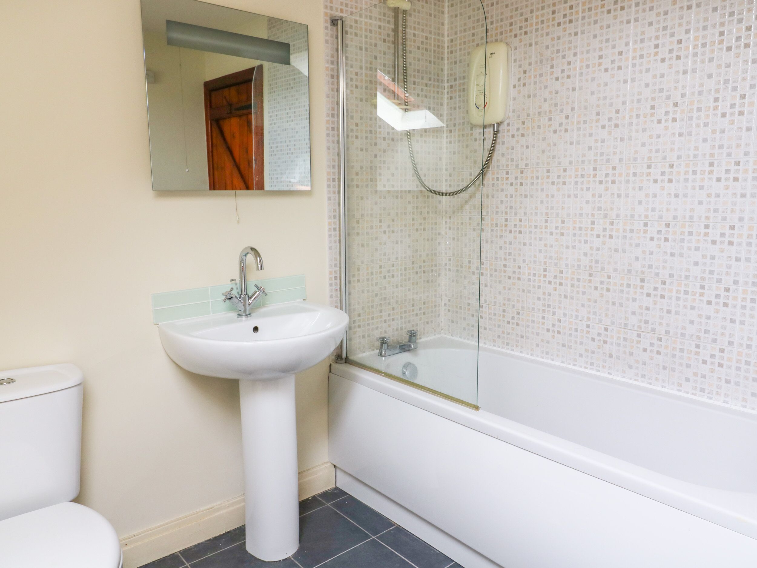 Un baño con lavamanos blanco, inodoro y bañera.