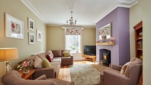 A cozy living room with a fireplace, comfortable seating, and a television.