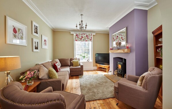 A cozy living room with a fireplace, comfortable seating, and a television. - Harbour House (Whitby)