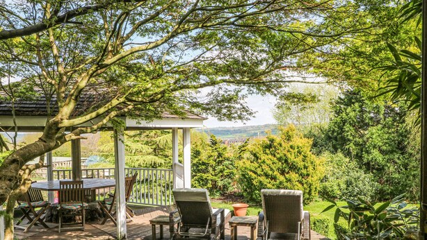 A wooden deck with outdoor furniture, a pergola, and lush greenery. - Frog Meadow Barn (Stoke-on-Trent)