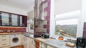 A modern kitchen with a built-in washing machine, a toaster, and a coffee maker. - Ty'r Orsaf (Builth Wells)