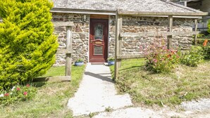 A stone building with a wooden door and a small porch.