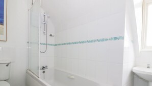 Un baño con bañera, inodoro y ducha.