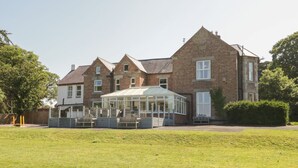 A large brick building with a conservatory and multiple windows. - Maes Elwy (Saint Asaph)