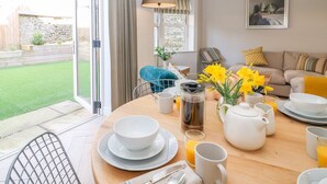 Ein Essbereich mit einem Tisch, der für das Frühstück gedeckt ist, einschließlich Schüsseln, Tassen und einer Kaffeekanne.