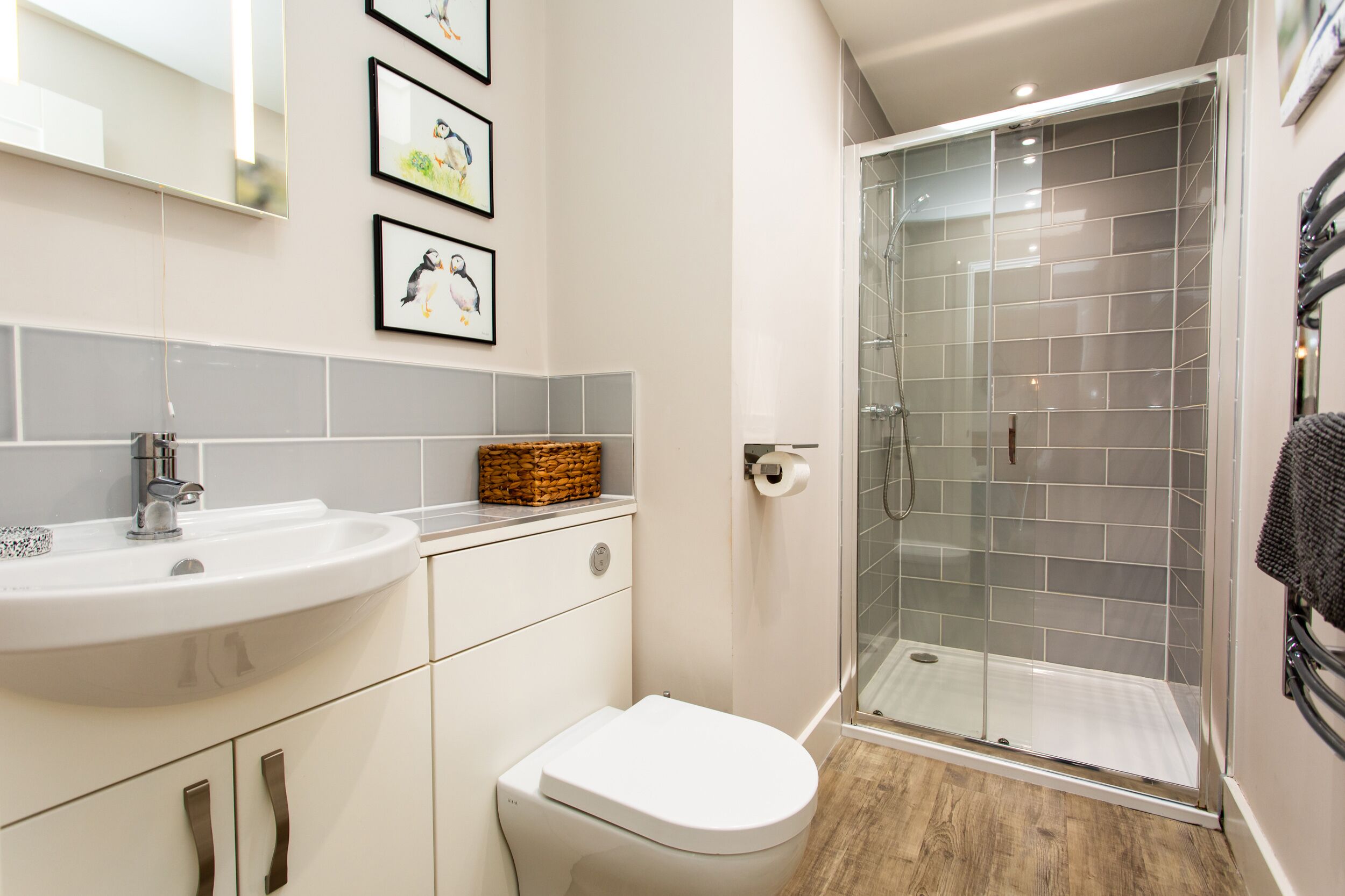 A bathroom with a white sink, a toilet, and a glass-enclosed shower.