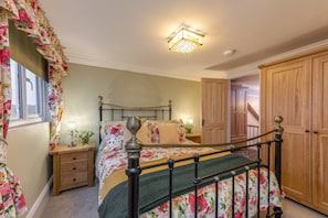 A bedroom with a bed, nightstand, and a wooden wardrobe. - See Glympse (Whitby)