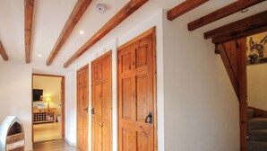 Un couloir avec des portes en bois, un escalier et un plancher en bois.