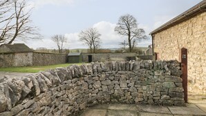 Un muro de piedra junto a un edificio de piedra.