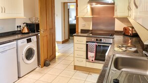 Una cocina moderna con electrodomésticos de acero inoxidable, horno empotrado y lavavajillas.