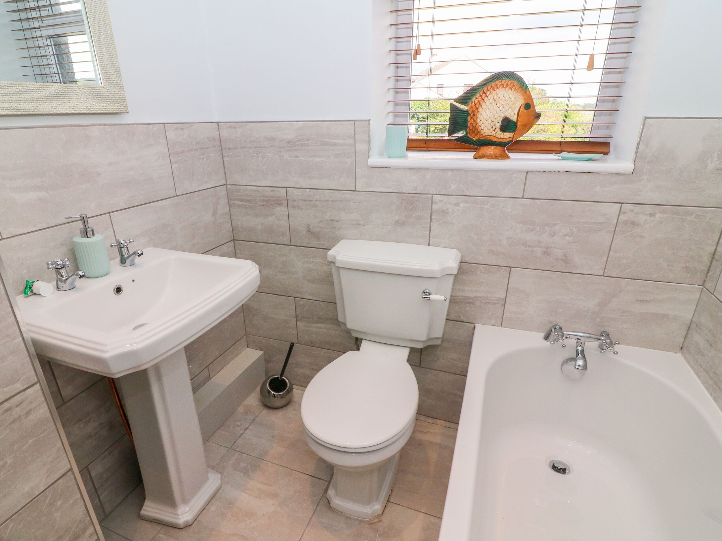 Een badkamer met een wastafel, toilet en bad.
