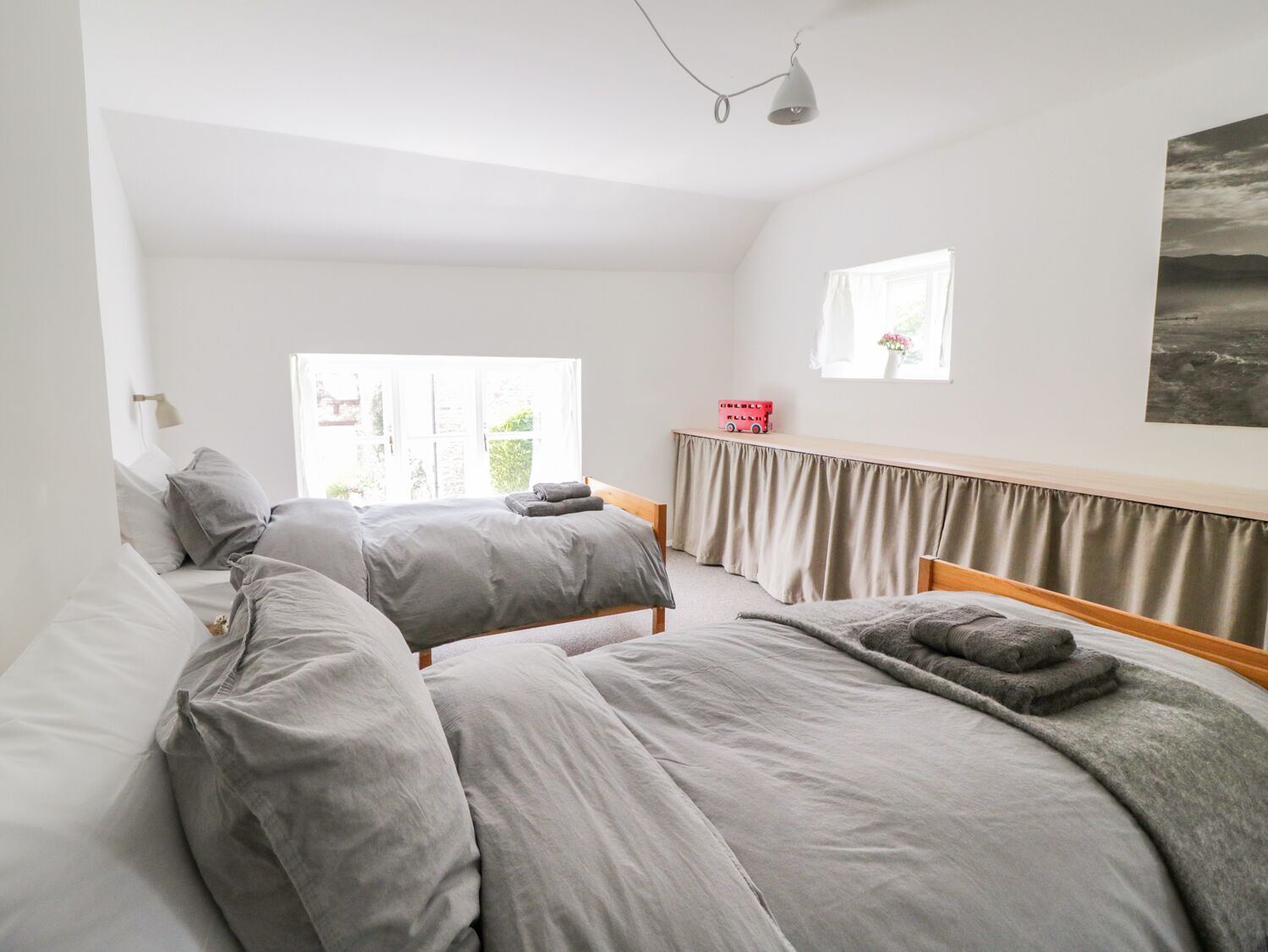 Une chambre avec deux lits, une fenêtre, une lampe et une vue sur l’extérieur.
