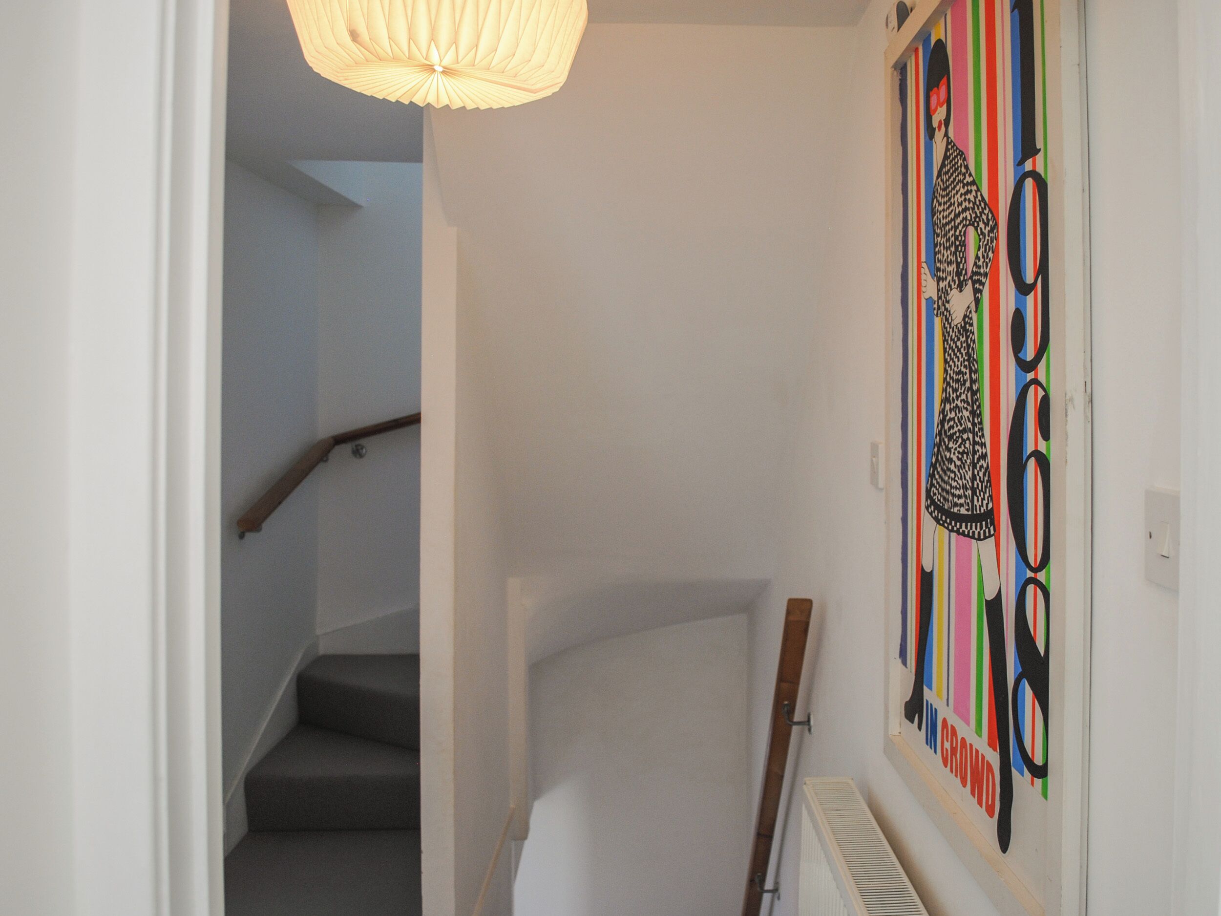 Un escalier avec une rampe en bois et un mur blanc.