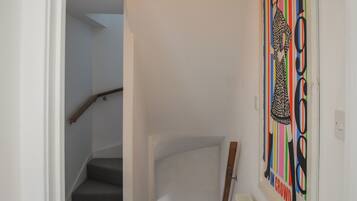 Un escalier avec une rampe en bois et un mur blanc.