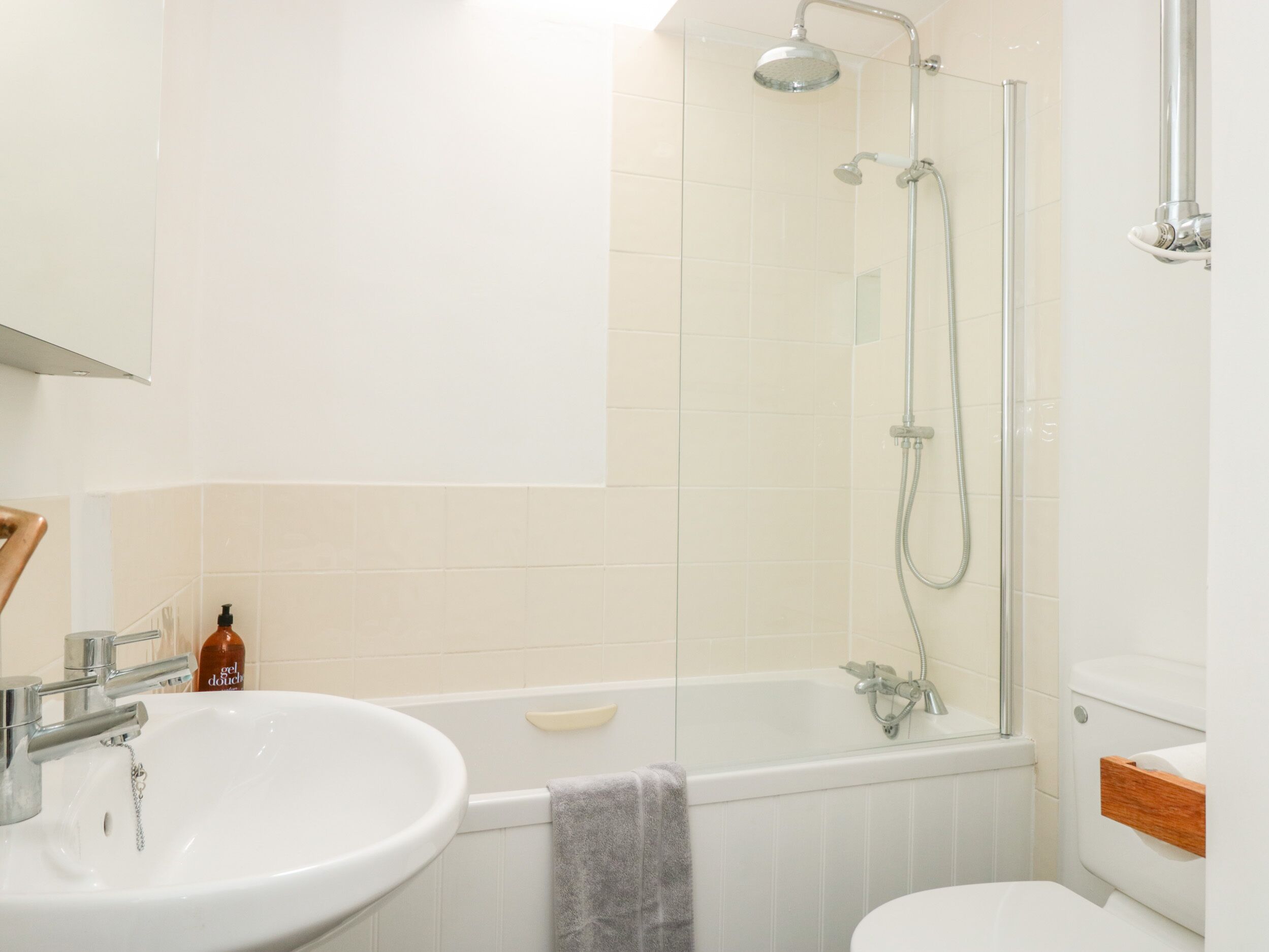 A modern bathroom with a white sink, a bathtub, and a shower.