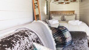 A cozy bedroom with a bed, a sofa, and a mirror. - The Lamb Shack (Bodmin)
