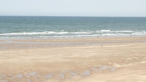 A wide beach with a clear view of the ocean.